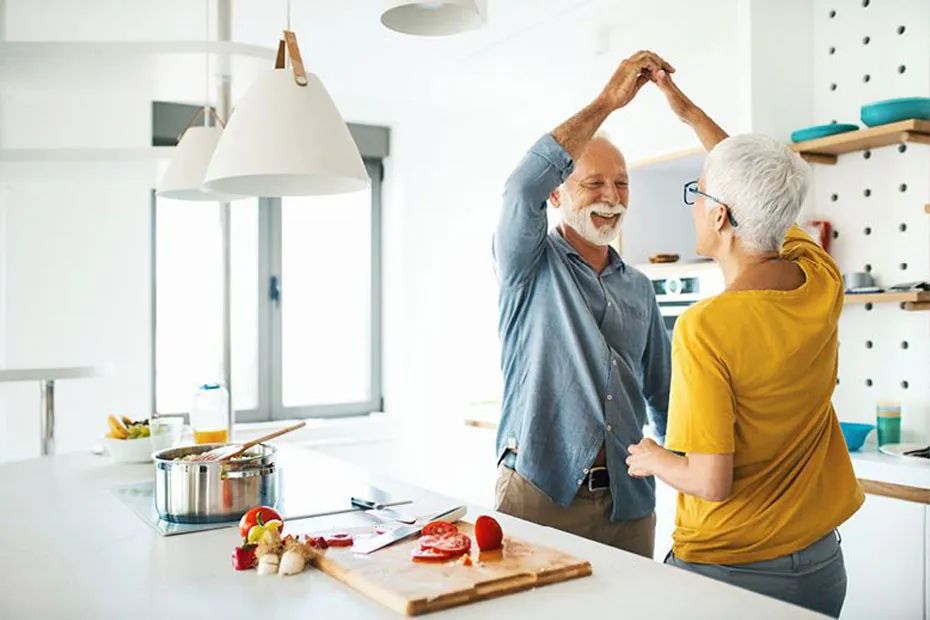 d'âge mûr dansant ensemble dans la cuisine pendant la cuisson