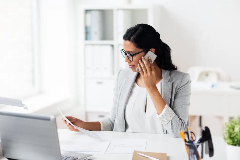 femmes utilisant leur téléphone portable pour examiner des documents afin de comprendre les transferts de solde de carte de crédit
