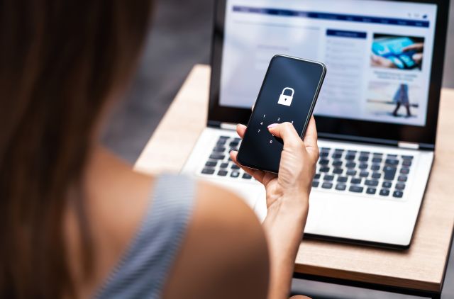 Une femme regarde l’écran de verrouillage de son appareil mobile