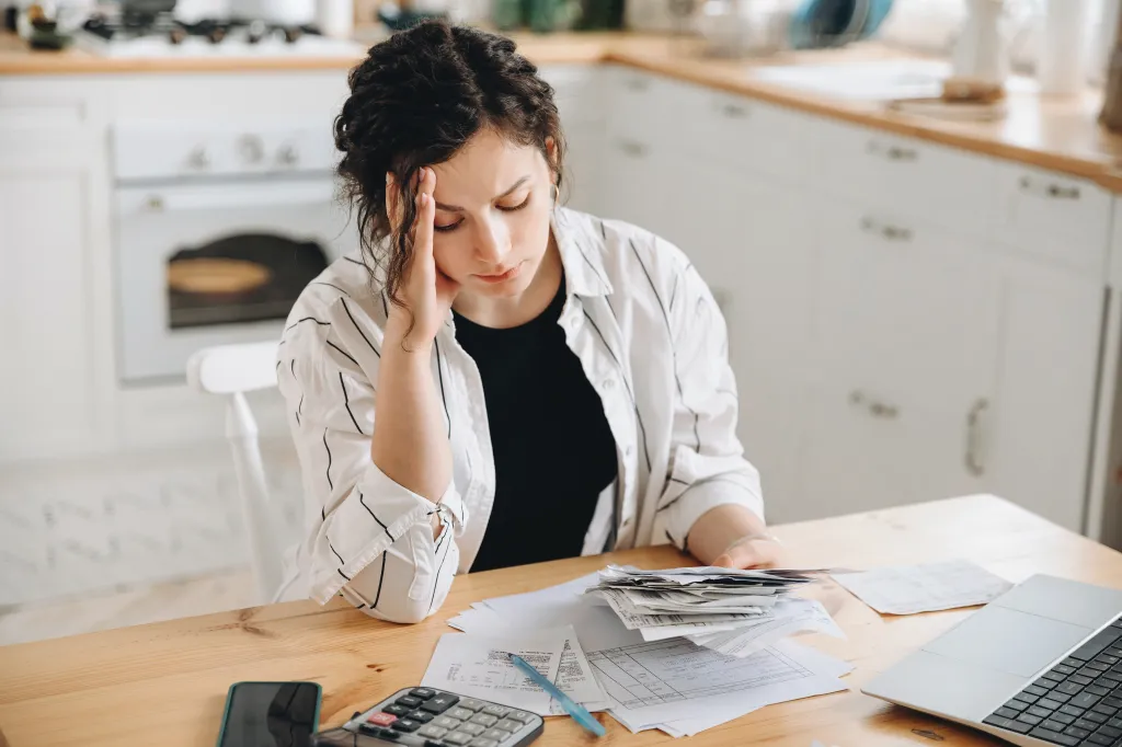 Stressed caucasian woman trying to cope with financial stress, having problems finding money to pay utility bills or loans.