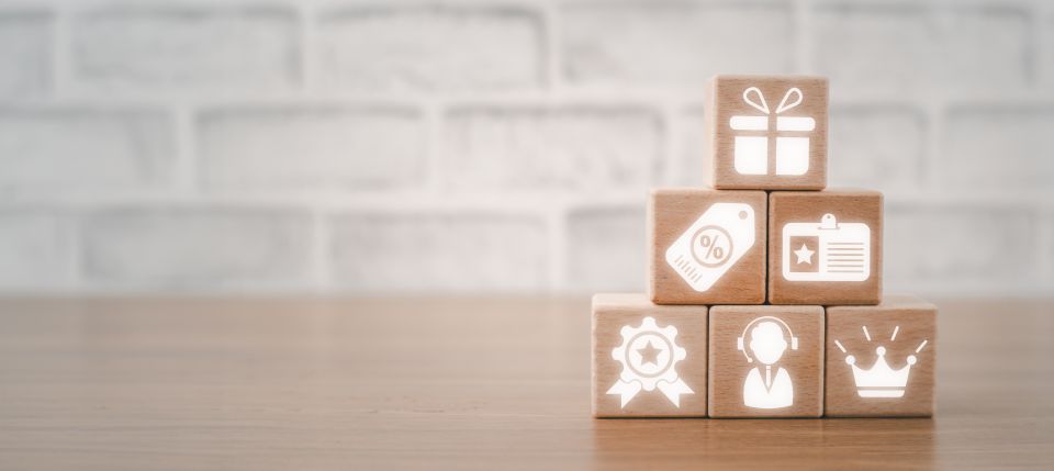 Concept des programmes de fidélisation, bloc de bois sur un bureau avec icône des programmes de fidélisation sur écran virtuel
