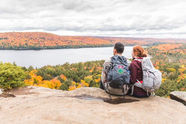 Jeune couple qui fait de la randonnée en montagne et se détend face à un parc canadien