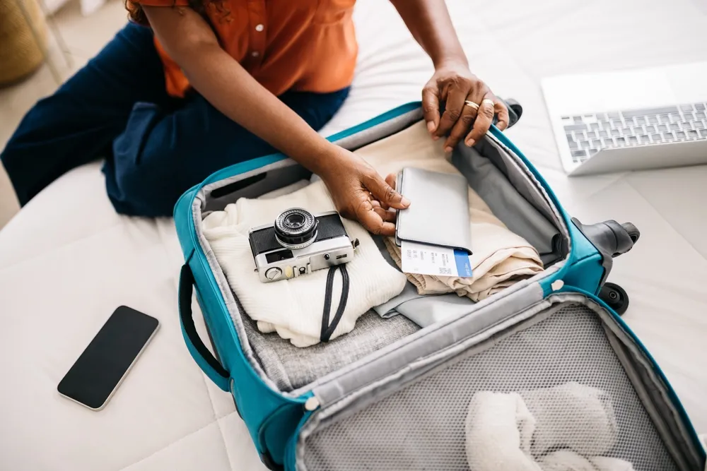 Femme emballant sa valise pour voyager.
