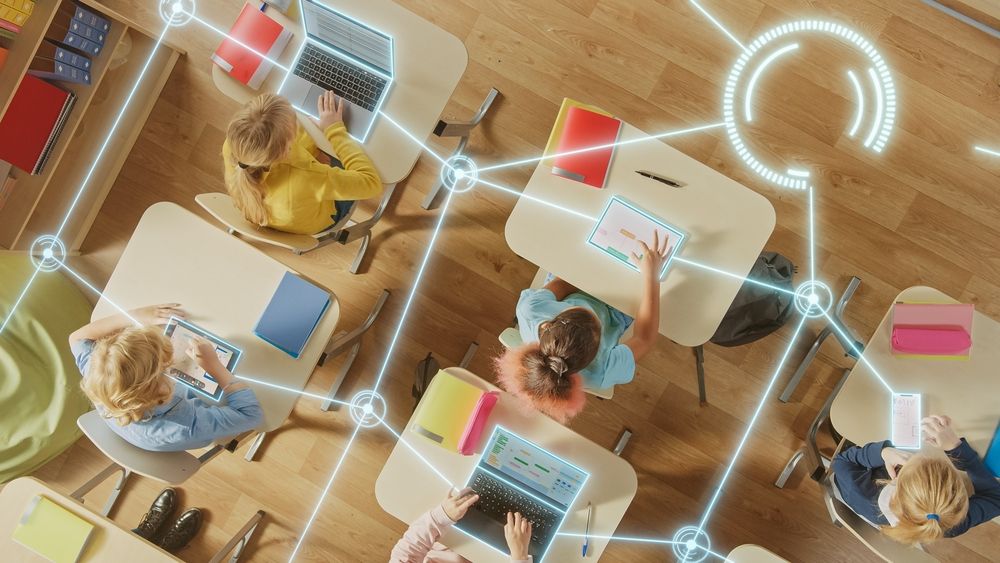 Les jeunes enfants dans une salle de classe apprennent à être instruit numériquement tout en étant en ligne.