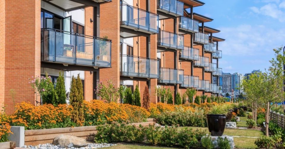 Rangée d'immeubles d'appartements modernes avec un jardin devant.