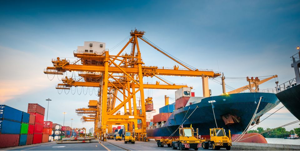 Grue jaune dans un port canadien avec un navire et des conteneurs d'expédition